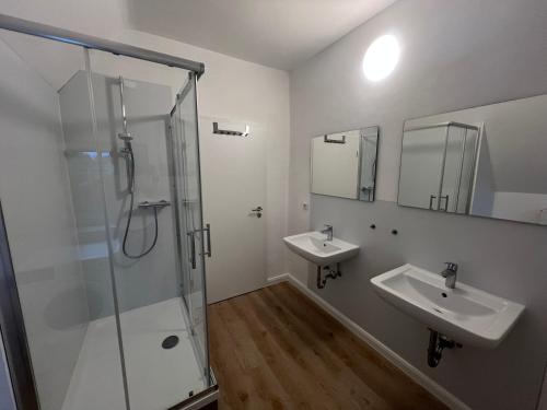 a bathroom with two sinks and a shower at Etzhorner Tied 3 in Oldenburg