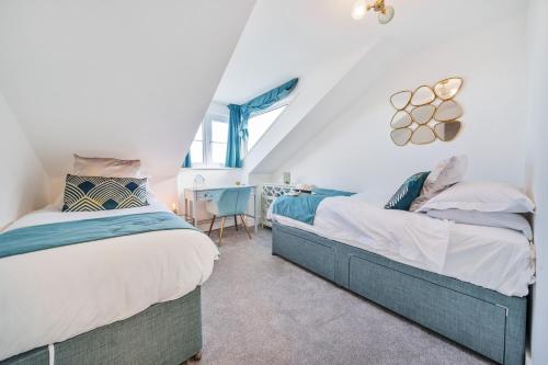 two beds in a attic bedroom with a desk at NEW! Stunning 2 Bed Beach Front Penthouse Apartment - Topaz, Compass Point in Carbis Bay