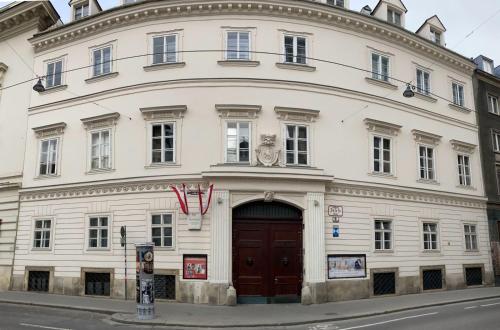 a large white building with a red door at Sissi Suite in center of Vienna in Vienna