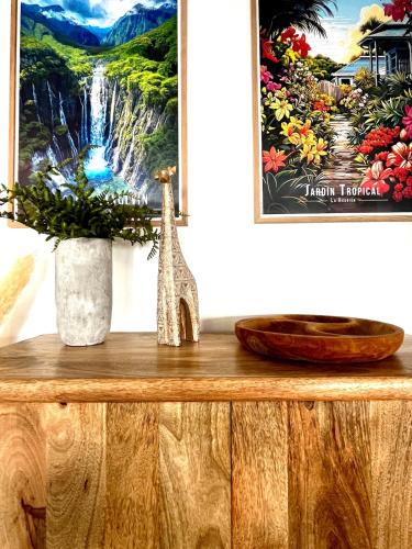 a table with a painting and a vase on it at Bleu Saline - Plage 250m in La Saline les Bains