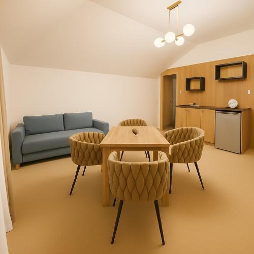 a living room with a couch and a table and chairs at Resort EDEN - domki, pokoje, apartamenty, sauna, jacuzzi in Jastrzębia Góra