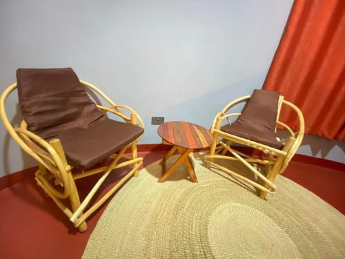 two chairs and a table in a room at Lucky Monkey Lodge in Arusha