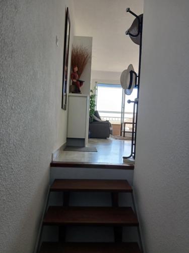 un couloir avec un escalier menant au salon dans l'établissement Appartement Entre port et mer haut standing, à La Grande Motte