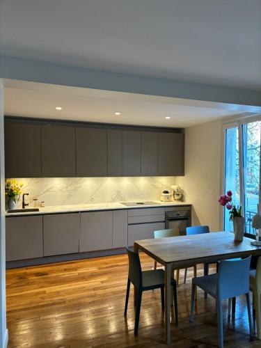 une cuisine avec une table et une salle à manger dans l'établissement Appartement design avec terrasse, à Boulogne-Billancourt