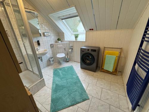 a bathroom with a washing machine and a sink at Fewo Naturblick in Wiesenthau