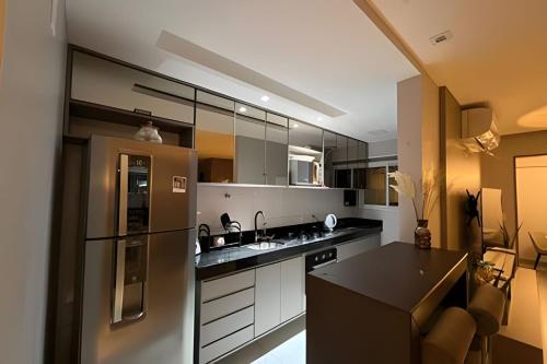 a kitchen with a refrigerator and a black counter top at Ed. Mandarim in Curro Velho