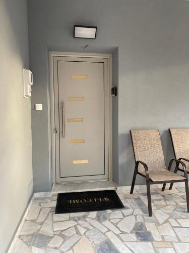a door with a fire place next to two chairs at Family house near Lefkada in Vonitsa