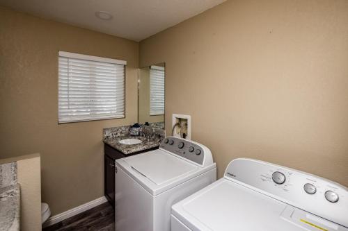a laundry room with a washing machine and a sink at Desert Dreaming Pool Fire Pit Game Room in Lake Havasu City