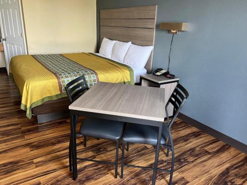 a room with a bed and a table and chairs at Knights Inn Lumberton in Lumberton