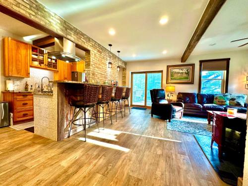 a kitchen and living room with a bar and a couch at Be Still & Know, Fireplace, Firetable, Walk to Port in Port Washington