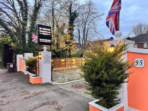 a house with a flag on the side of it at All Seasons Gatwick Guest House & Parking in Horley