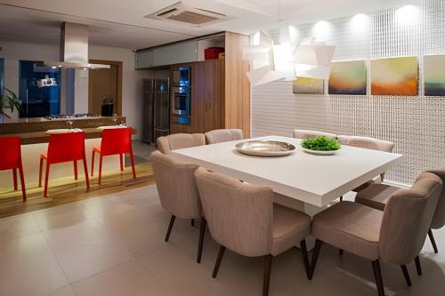 a kitchen and dining room with a white table and chairs at Casa moderna com 4 suítes e terraço in Curro Velho