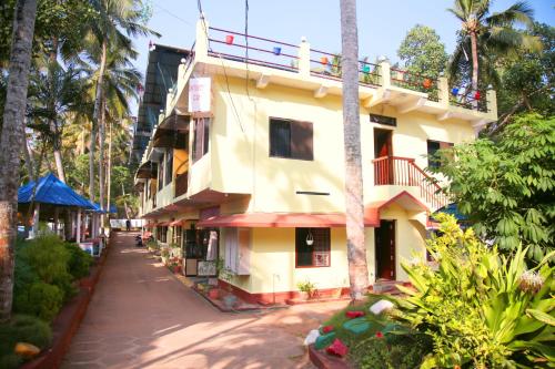 een geel gebouw met een balkon in een straat bij Panchavadi Ayurvedic Beach Resort in Varkala
