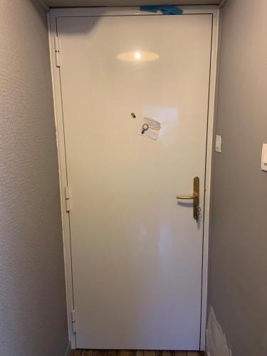 une porte blanche avec une étiquette dans l'établissement Appartement aux Sablettes, vue mer, plages en bas de la résidence, à La Seyne-sur-Mer