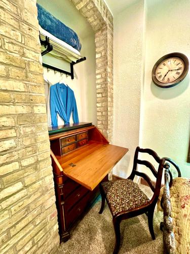 a room with a wooden desk and a clock on a wall at Be Still & Know, Fireplace, Firetable, Walk to Port in Port Washington