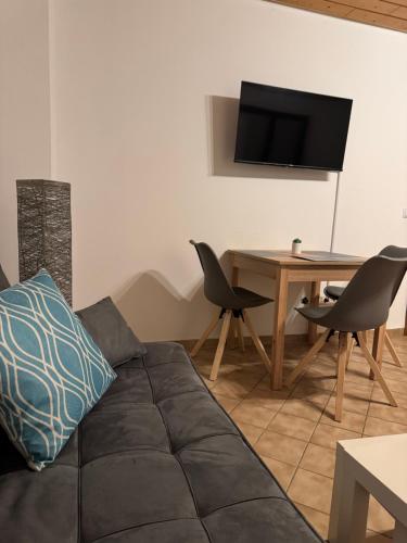 a living room with a couch and a table with a television at Monteurwohnung für 1-2 Personen Nähe Heidelberg Mannheim in Birkenau