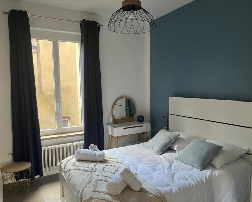 une chambre avec un grand lit blanc et une fenêtre dans l'établissement Les Carmes - Logement entier, appartement, Vienne - France, à Vienne