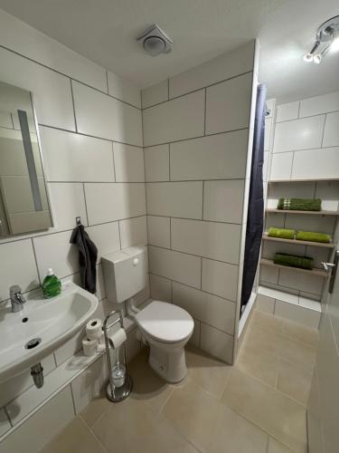 a white bathroom with a toilet and a sink at Monteurwohnung für 1-2 Personen Nähe Heidelberg Mannheim in Birkenau