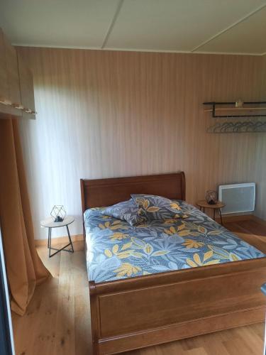 une chambre avec un lit avec une couette bleue dans l'établissement Green cube, à Sornac