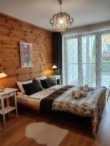 a bedroom with a large bed and a chandelier at Willa na Wilcznik in Zakopane