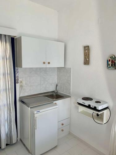 a small kitchen with a sink and a stove at Endless Blue Studios in Myrtos
