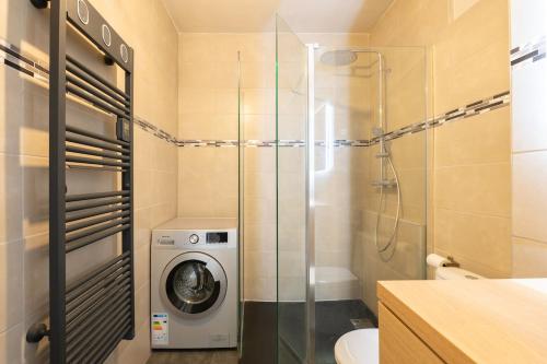 La salle de bains est pourvue d'un lave-linge et d'une douche en verre. dans l'établissement Studio Port Hyères Vue Mer - Wifi - Climatisation, à Hyères