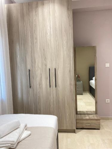 a bedroom with a large wooden cabinet with a mirror at Family house near Lefkada in Vonitsa