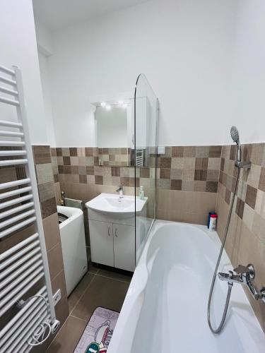a bathroom with a bath tub and a sink at Central Perk Apartman in Balatonalmádi
