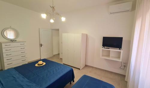 a bedroom with a blue bed and a tv at Lucy Apartment sul lungomare in Maiori