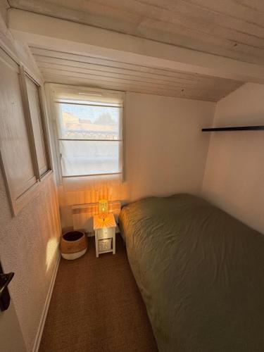 une petite chambre avec un lit et une fenêtre dans l'établissement Charming mini-villa, à Sanary-sur-Mer