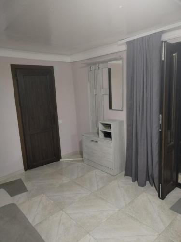 a room with a door and a dresser and a mirror at Lyucie Guest House Ijevan in Ijevan