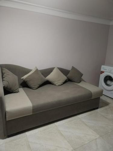 a couch with four pillows on it in a living room at Lyucie Guest House Ijevan in Ijevan
