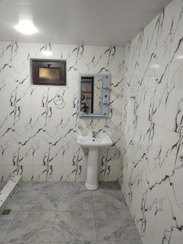 a white bathroom with a sink and a mirror at Lyucie Guest House Ijevan in Ijevan