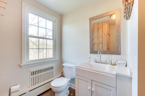 a bathroom with a toilet and a sink and a mirror at Pet Friendly Historic East Stroudsburg Manor in East Stroudsburg