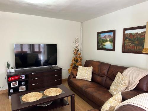 a living room with a couch and a flat screen tv at Casa Palafox Fitero in Fitero