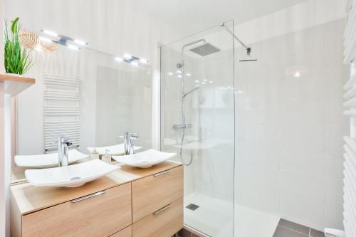 une salle de bain avec deux lavabos et une douche dans l'établissement Chill 2 à Paris La Défense Arena, à Nanterre