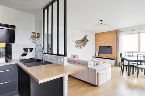 une cuisine et un salon avec un canapé et une table dans l'établissement Chill 2 à Paris La Défense Arena, à Nanterre