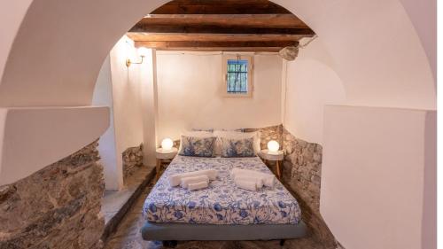 a bedroom with a bed with two pillows at La Casa delle Pietre Parlanti - Casa in pietra ai piedi del parco delle 5 Terre in Biassa