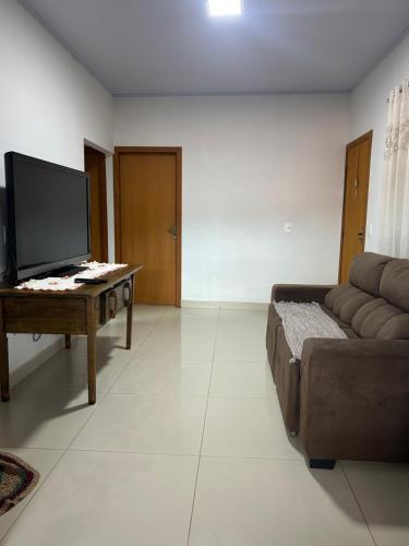 un soggiorno con divano e TV a schermo piatto di Casa melo a Pirenópolis