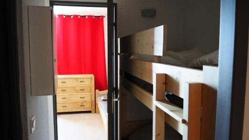 une chambre avec un lit et un rideau rouge dans l'établissement Résidence Median - Studio rénové · Proche des pistes · Balcon MAE-1954, aux Menuires
