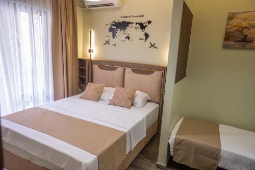 a bedroom with a bed and a world map on the wall at Hana Apartments in Ulcinj