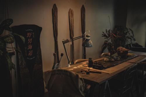 a room with a table with a lamp and some skis at 旅兜- house in Lanyu