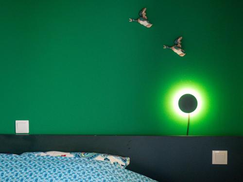 a green bedroom with a bed and a green wall at Andar`s people in Sarajevo