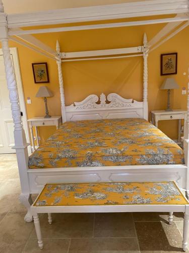 una camera da letto con un letto bianco con baldacchino di Chambre d'Hôte Couguiolet - avec piscine a Foissac