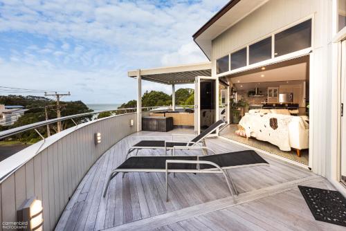 a balcony with a view of a house at Funky Beach House with sea and country views in Orewa