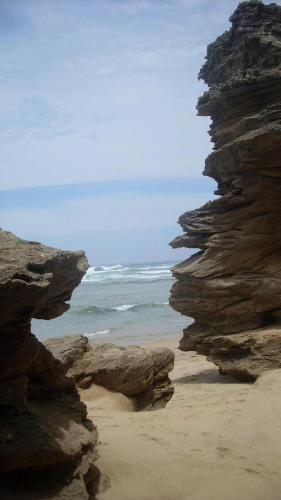 a view of a beach with rocks and the ocean at Shearwater on Sea 106 in Sedgefield