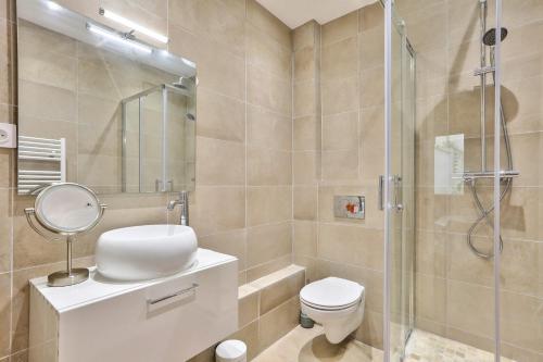La salle de bains est pourvue d'un lavabo et d'une douche. dans l'établissement Modern and peaceful apartment - 1BR 5P - Sentier, à Paris