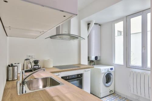 une cuisine avec un évier et une machine à laver dans l'établissement Modern and peaceful apartment - 1BR 5P - Sentier, à Paris