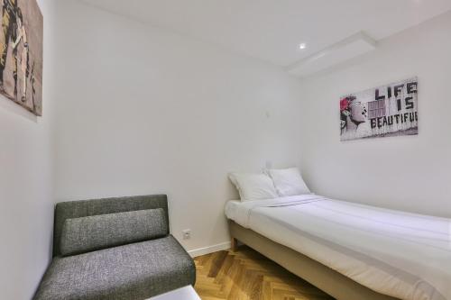 une petite chambre avec un lit et une chaise dans l'établissement Modern and peaceful apartment - 1BR 5P - Sentier, à Paris