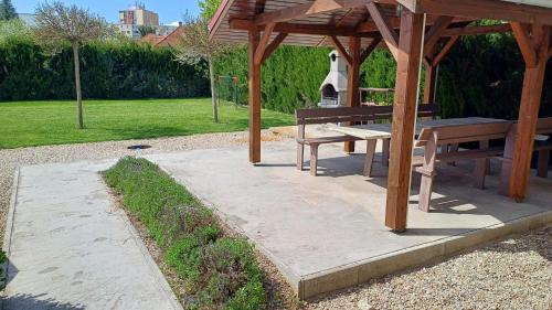a picnic table and a bench under a gazebo at La Familia in Štúrovo